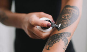 Nakladanie Kremu Do Opalania Na Tatuaz Na Przedramieniu